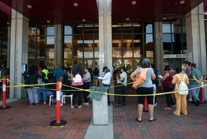 People wait in line in front of building
