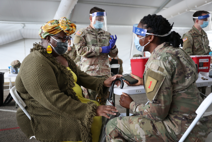 A U.S. Army soldier from the 2nd Armored Brigade Combat Team, 1st Infantry Division, prepares to immunize Tangela C. Mitchill with the COVID-19 vaccine at the Miami Dade College North Campus on March 10, 2021 in North Miami, Florida.