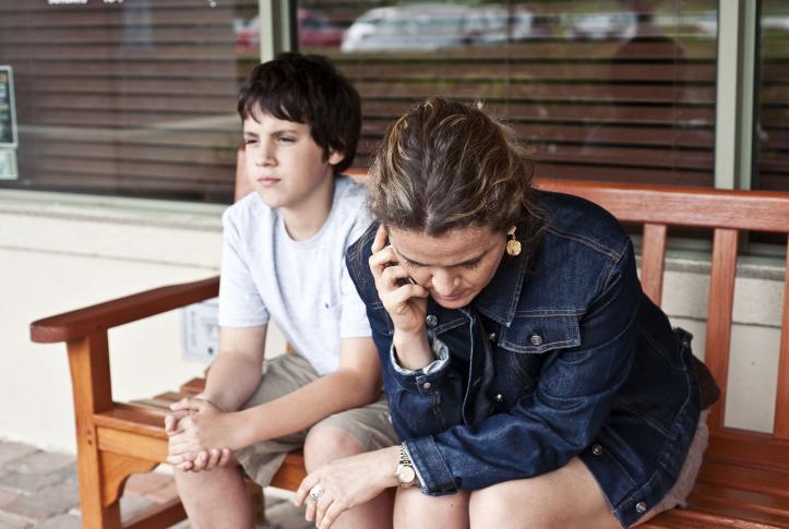 Woman talking on phone sitting next to her son