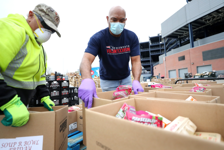 Volunteers deliver boxes of foods to families on May 8, 2020 in Foxborough, Mass. The Centers for Medicare and Medicaid services recently approved section 1115 demonstrations in Massachusetts in three other states that include innovative funding for addressing social drivers of health, such as nutrition-related services. Photo: Maddie Meyer/Getty Images