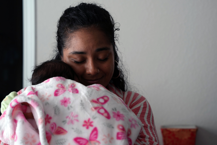 Doula snuggles baby in blanket