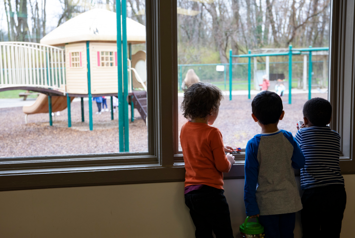 Children look out at playground through window