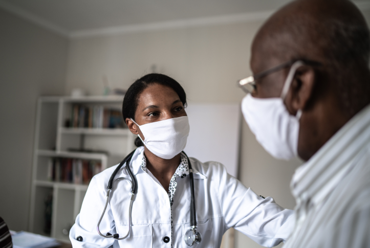 Doctor in mask comforts patient in mask in doctor's office