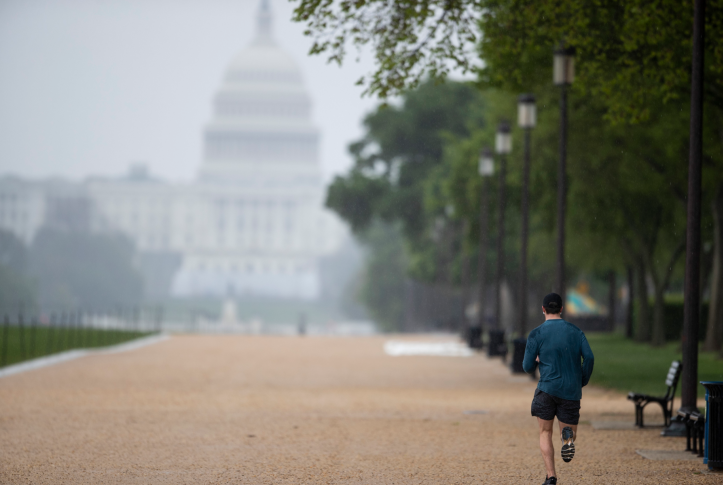 A man runs with the U.S. Capitol building in the background in Washington D.C.