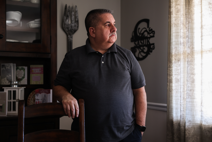 Man stares out window in own home