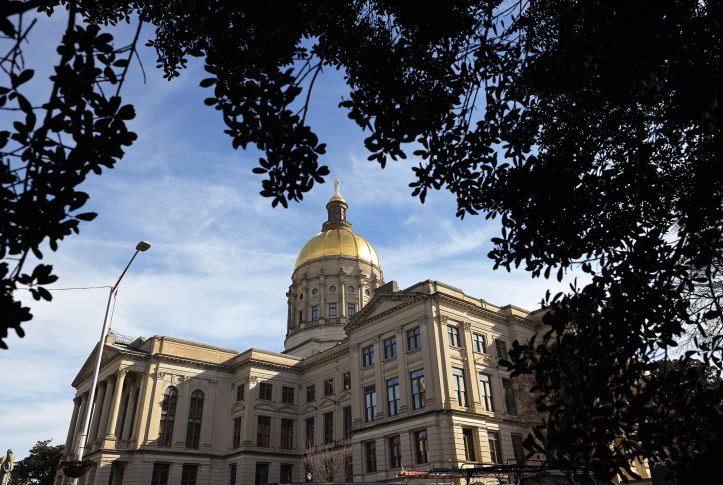 Side view of state capitol building from under a tree