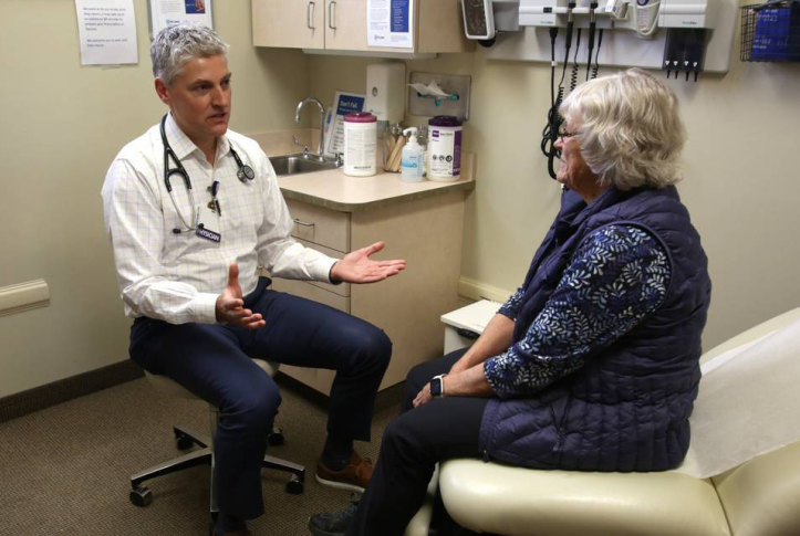 Doctor consulting elderly woman in exam room