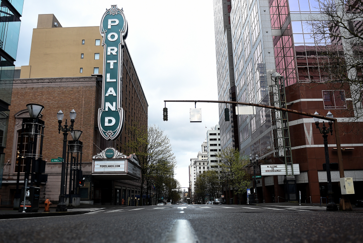 shot of a Portland, Oregon street with a big Portland sign on a theater. 