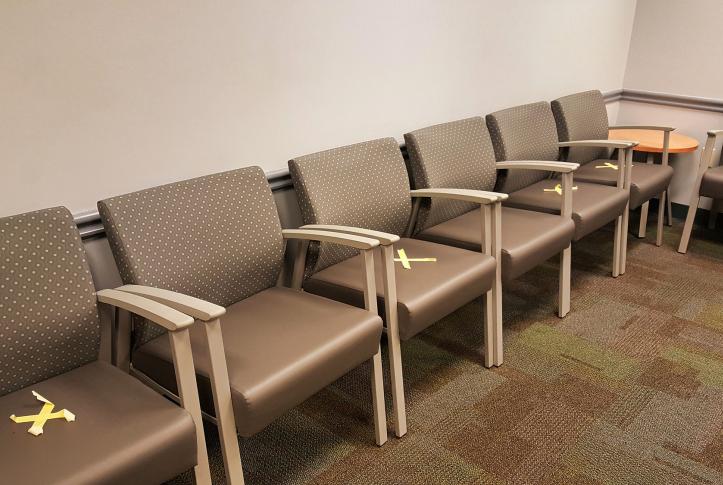 Chairs blocked off in an empty doctor's office waiting room