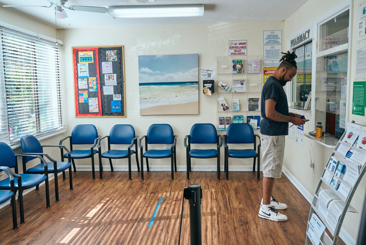 Man stands at check-in desk at waiting room