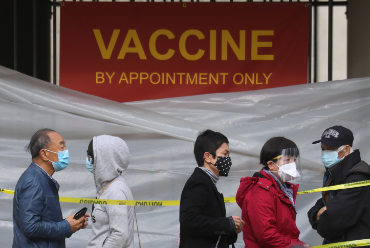 People with appointments stand in line to receive the COVID-19 vaccine at a vaccination site at Lincoln Park in East Los Angeles amid eased lockdown restrictions on January 28, 2021 in Los Angeles, California.