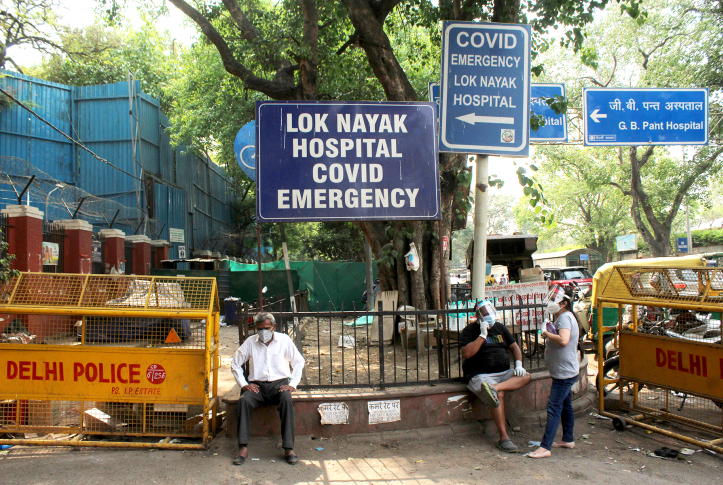 A patient with difficulty in breathing sits outside the Lok Nayak Jai Prakash Narayan Hospital, one of the largest facilities for COVID-19 patients, in New Delhi on April 28, 2021.