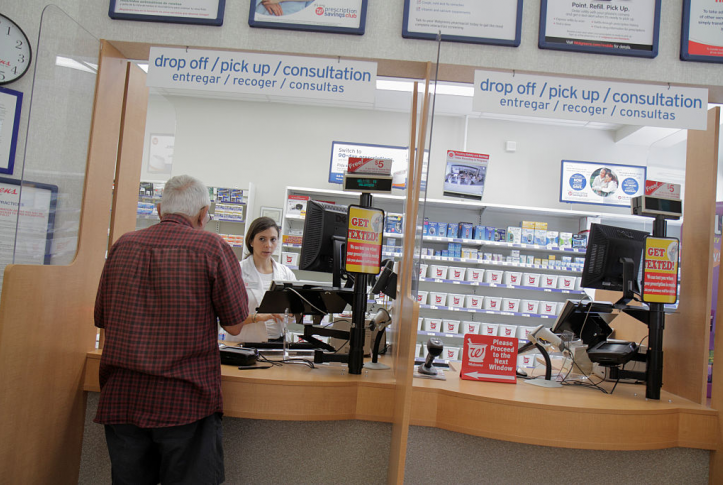 senior man gets prescriptions at pharmacy counter