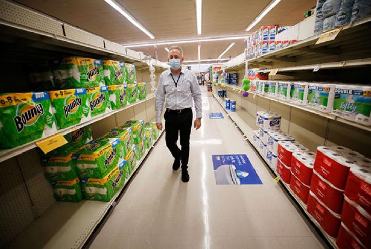 Senior worker in grocery store ready for COVID-19