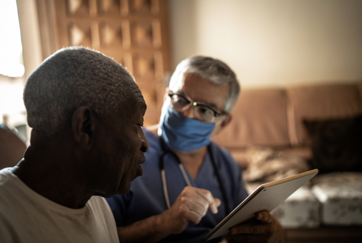 Health visitor and a senior man during home visit