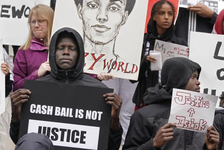 Cash bail protestors holding signs