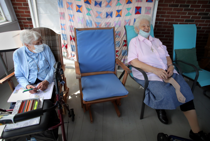Gloria Cote, 92, left, and Sr. Jeanne Fregeau, 93, sit on the porch at St. Chretienne Retirement Residence in Marlborough, Mass., on Aug. 26, 2020. Both recovered from COVID-19 infections earlier in the year. The pandemic has prompted increased investment in home- and community-based services to transform care settings and expand options for long-term care. Photo: Craig F. Walker/Boston Globe via Getty Images