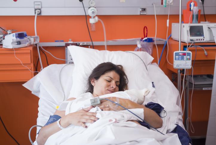 Woman at the hospital holding her newborn baby in France