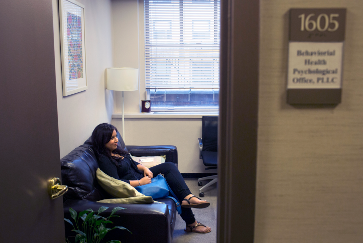 Photo, woman sits on couch in office