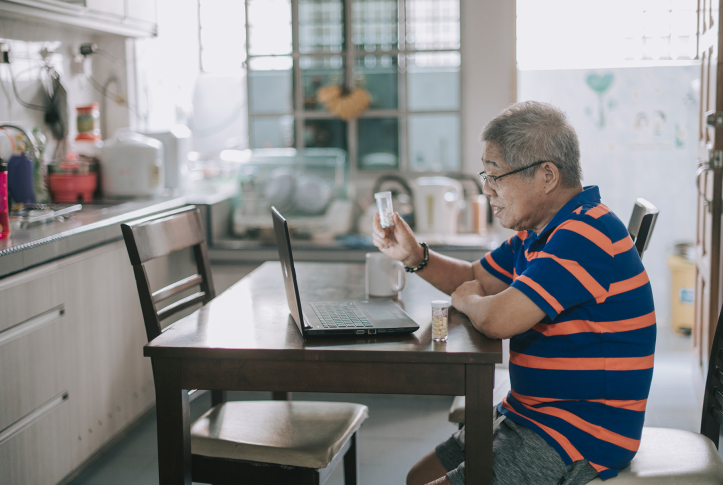 Chinese senior man video conferencing with his doctor from home