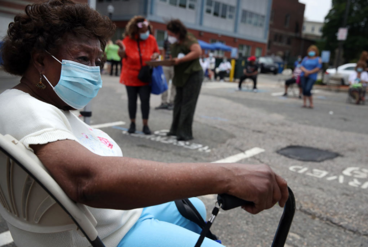 A woman waits to be tested for COVID-19 outside the Catherine Hardaway Residences in the Roxbury neighborhood of Boston, Mass., on July 8, 2020. A full day of free community-based testing for the elderly and people with disabilities took place at Central Boston Elder Services. Photo: Craig F. Walker for the Boston Globe via Getty Images