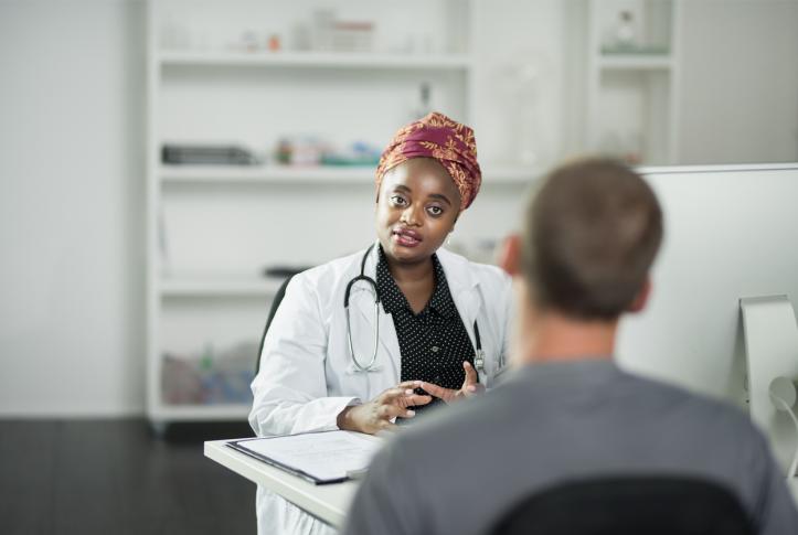 primary care physician listens to low-income patient