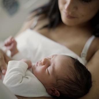 Mom holding sleeping newborn baby