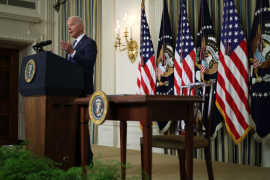 President Biden speaking at podium in front of American flags and white house seal.
