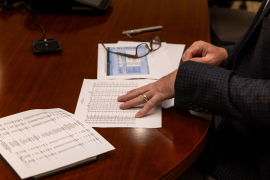 Hand looks at paper work on table