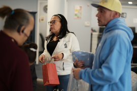 Woman packs bag with two other people