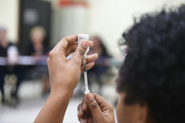 Patient educator holds syringe up to examine it