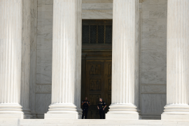 Law enforcement officers stand on the top steps of the U.S. Supreme Court Building