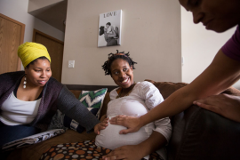 Two doulas examine pregnant patient at her home
