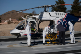 Medical workers load patient onto emergency ambulance