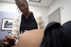 Midwife performs ultrasound on pregnant woman