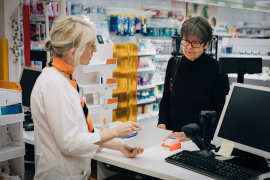 Pharmacist and patient discussing prescription drugs