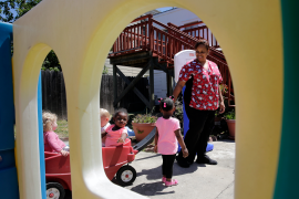 Daycare worker playing outdoors with toddlers