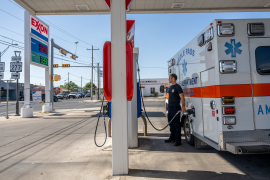 Photo, ambulance driver fills up ambulance at gas station
