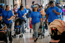 Photo, families wearing blue shirts on a stroller walk in the mall