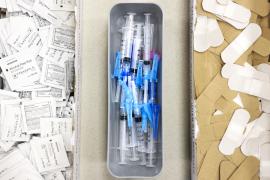 Alcohol swabs, vaccine needles, and bandages on a table