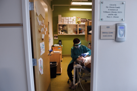 Dental hygenist in mask works on patient's mouth