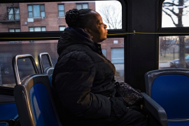 Woman sits on bus and stares into space
