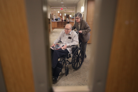 Photo, elderly woman pushing man in wheelchair