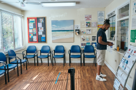 Man stands at check-in desk at waiting room