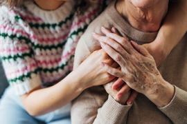 Mother and daughter embrace and hold hands