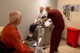 Elderly woman sits on exam table
