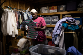 Photo, man folds clothes in dark closet