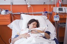 Woman at the hospital holding her newborn baby in France