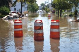 Photo, traffic barrels in the middle of the street submerged by flood waters